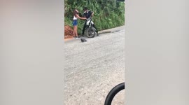 Man falls over trying to ride motorcycle with flat tire in Colombia