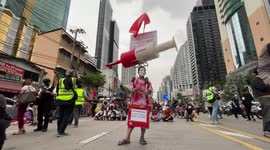 Activist dresses as giant Pfizer injection at protest in Thailand