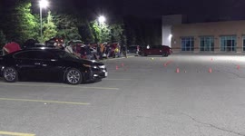 Long holiday labor day weekend fun late at night with people racing remote controlled cars in a parking lot near Toronto