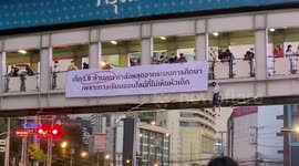 Student hangs from 30ft high walkway at protest in Thailand