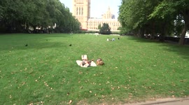 Londoners enjoy September sun in a park along the river Thames