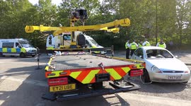 Police remove a Ford Ka used by protesters to lock and glue themselves into so they could block the A1020 near ExCeL London ahead of the DSEI  Arms show.