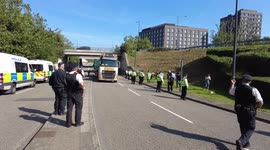 Protesters try to block Military vehicles arriving for DSEI Arms Fair but then sit in the road and block members of the public while Police officer jumps in a Lamborghini