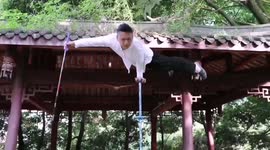 Chinese acrobat writes calligraphy while keeping balance on pole