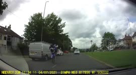 Motorbike does a wheelie in traffic then jumps a red light. Driver has no helmet.
