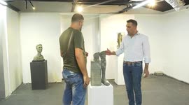 Palestinian artist Khaled Hussein, 46, displays his artworks in an exhibition