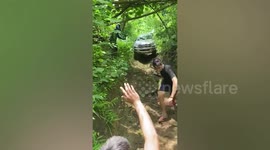Car struggles to drive down narrow dirt road in the Philippines