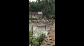 A Man Almost Falls Into The River And Hangs On The Edge Of The Bridge Helped By Residents Climbing The BridgeIn Banten Indonesia