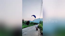 Paraglider becomes entangled in power lines after crash-landing in central China