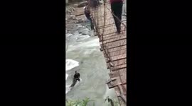 Man clings onto edge of bridge before being rescued by passing locals in Indonesia