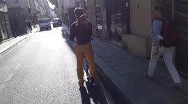 Man with his shiba inu dog in a backpack riding a shareable electric kickscooter in the streets of Paris. 16sept2021