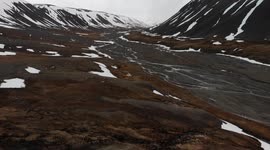 Magnificent Svalbard (Spitsbergen) drone view. Glacier in spring, mountains view near Longyearbyen. Snow around the river.