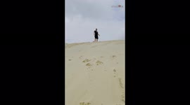 'Sandboarder 'thrown off' his board after a ride down a sand dune '