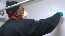 Grouting bathroom tiles in progress - basic repairs in a London flat