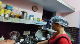 A Indian lady is doing cooking work too cover in head in funny ways