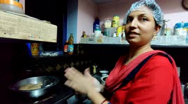A Indian lady is doing cooking work too cover in head in funny ways