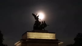 Harvest full moon rises over statues in Hyde Park in London
