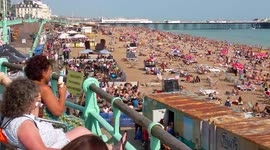 Crowded beach in Brighton, UK during summer heatwave