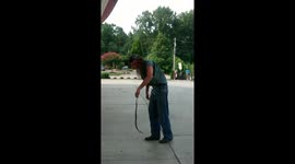 Snake tries to crawl up man's trousers at gas station