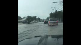 Cars drive through Miami flooding