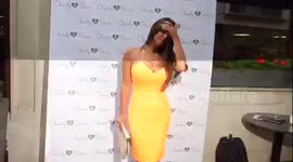 Casey Batchelor in orange at charity event