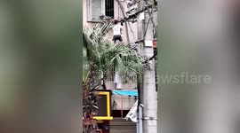 Firefighters, police and residents team up to rescue toddler hanging from second-floor window in China