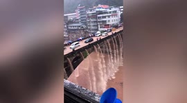 Water cascades from flooded bridge like waterfall in southern China