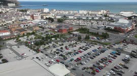 4K aerial footage: Panicked drivers queue to buy fuel and block car park exits at Asda Llandudno