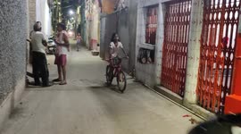 The tiny funny kids racing by bycicle in Indian street