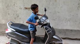 A Funny tiny boy trying to fast drive in Indian street