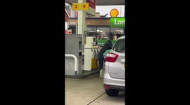 Desperate Deliveroo moped rider fills up jerry can at London petrol station