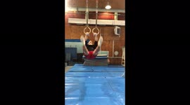 The gymnast demonstrates strength elements on the rings.