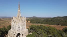 Beautiful monastery of Montserrat, with cultivated fields, bells and the blue sky in the background