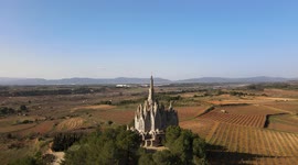 Beautiful monastery of Montserrat, with cultivated fields, bells and the blue sky in the background