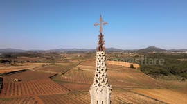 Beautiful monastery of Montserrat, with cultivated fields, bells and the blue sky in the background