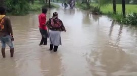 Healthcare workers cross overflowing drain to conduct vaccination drive in central India
