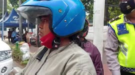 A woman does not accept her motorbike being lifted when she is caught in an illegal parking raid in Central Jakarta Indonesia