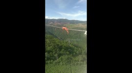 Vietnamese electrician untangles wire on power line hundreds of metres high in strong winds