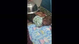 A funny baby boy put a port his back good sign in South India