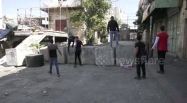 Palestinian protesters hurl stones towards Israeli troops during clashes in the West Bank city of Hebron.
