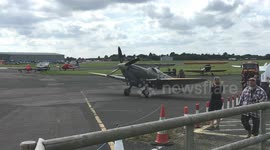 Small boy imagines he is flying beside a Spitfire at former RAF fighter base