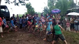 Kids play tire racing game in the Philippines countryside