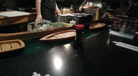 sushi bar in Berlin. Sushi is sailing by boat. They float right down the bar in front of the client.