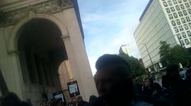 Protesters demonstrate outside the 2021 Conservative Party Conference in Manchester, UK. Boy gives middle finger.