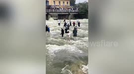 Residents catch fish in river when reservoir discharges floodwater in China