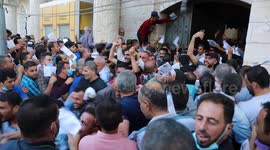 Palestinian citizens wait in front of the Gaza Chamber of Commerce and Industry headquarters to register in order to work inside the Israel territories, in Jabalia