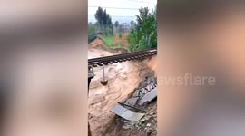 Rainstorm causes bridge to collapse leaving train hanging on unstable track