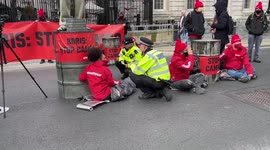 Police try to convince Greenpeace activists to end their protest in front of Downing Street