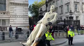Police remove Boris Johnson statue covered with tar from entrance of Downing Street