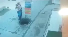 Shocking moment as mother & child fell in manhole while talking to phone in Northern India.